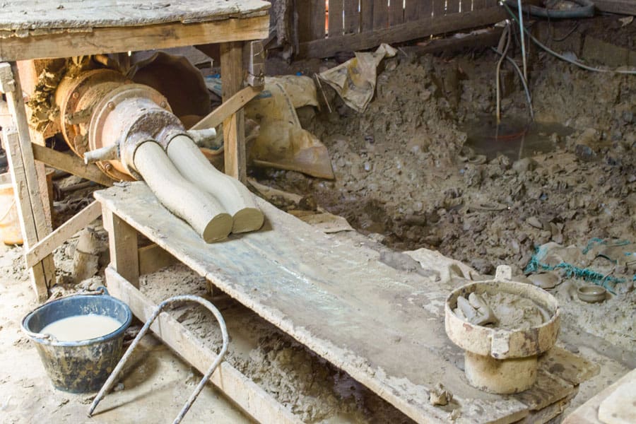 A Picture of a Pug Mill Extruding Clay