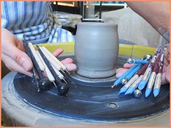 a picture of a potter holding an 18 pc set of modeling tools