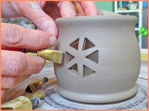 a picture of a potter using a triangle shaped cutter