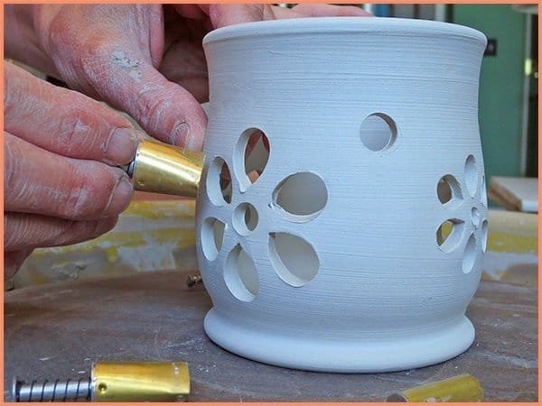 a picture of a potter using a teardrop shaped cutter