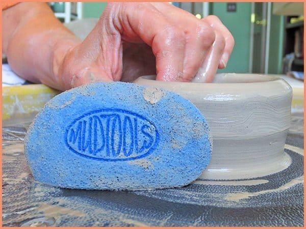 a picture of a potter displaying a blue sponge tool