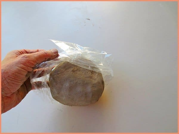 picture of wedged recycled clay being placed in a plastic bag