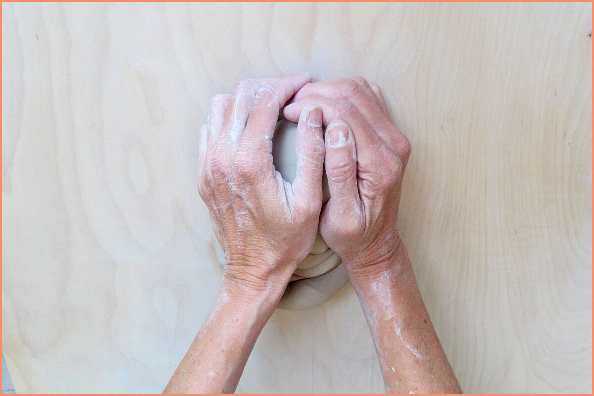 a picture of a potter pushing the spiral wedge down