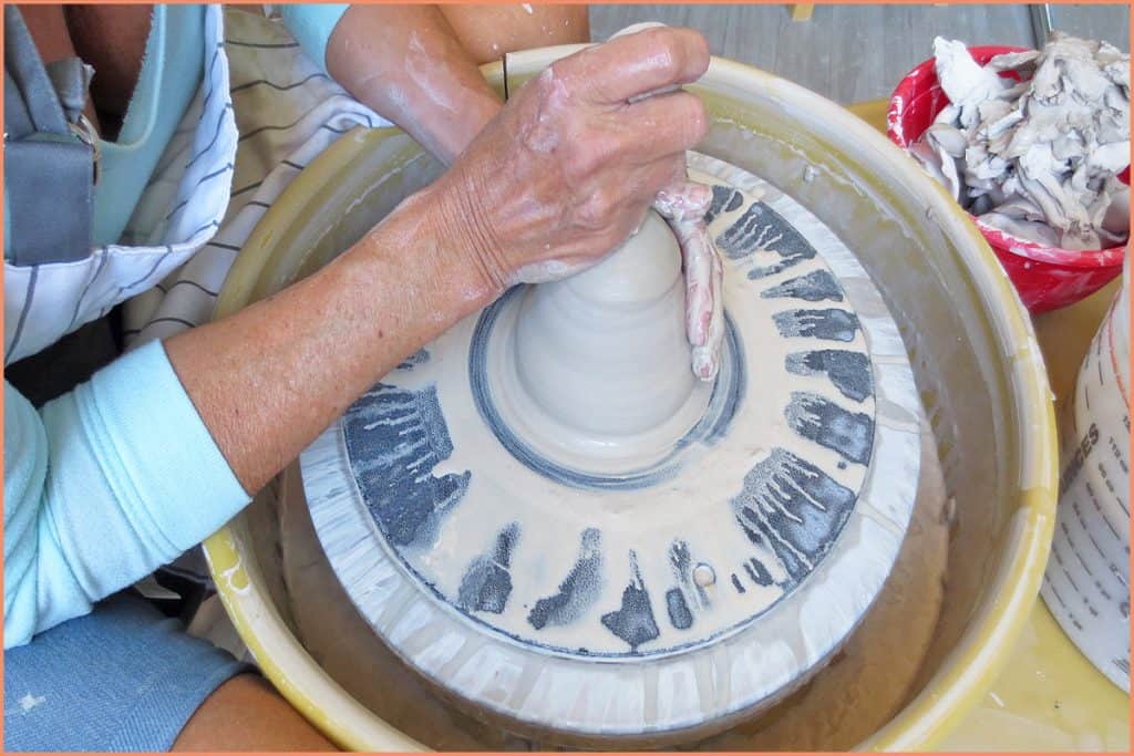 a picture of a potter forming a bee hive on the potters wheel