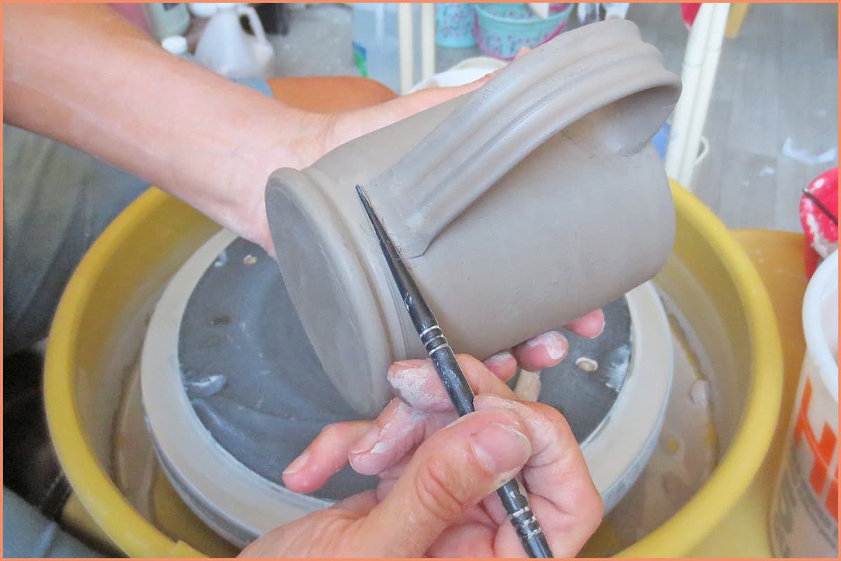 a picture of a potter using a plastic modeling tool
