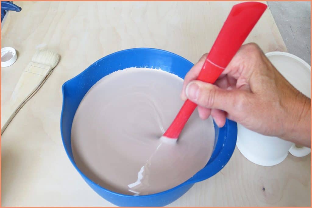 a picture of a potter slowly stirring glaze