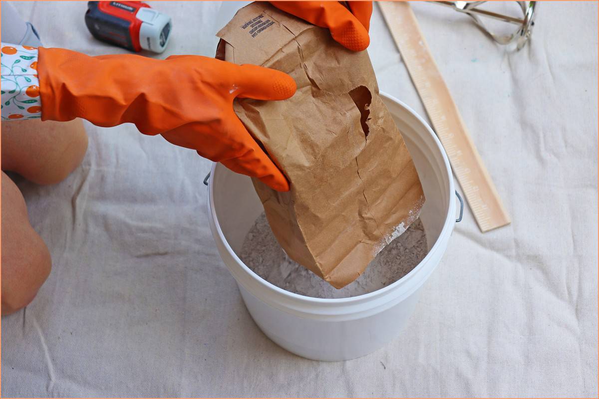 a picture of a potter placing dry glaze in bucket