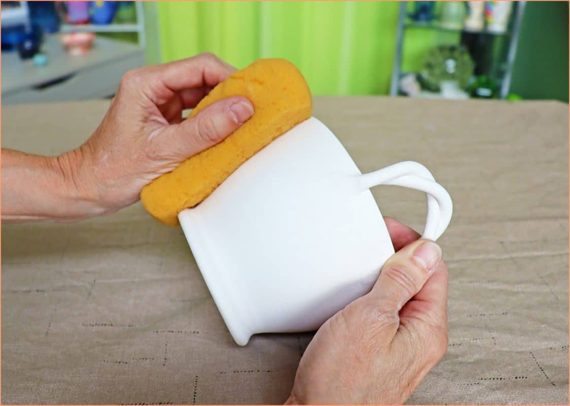 a picture of a potter cleaning bisque ware