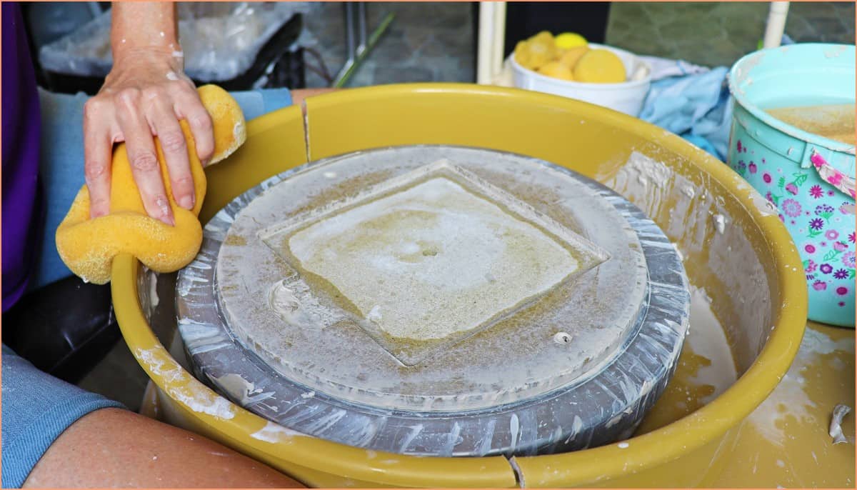 a picture of a potter sponge cleaning the pottery wheel