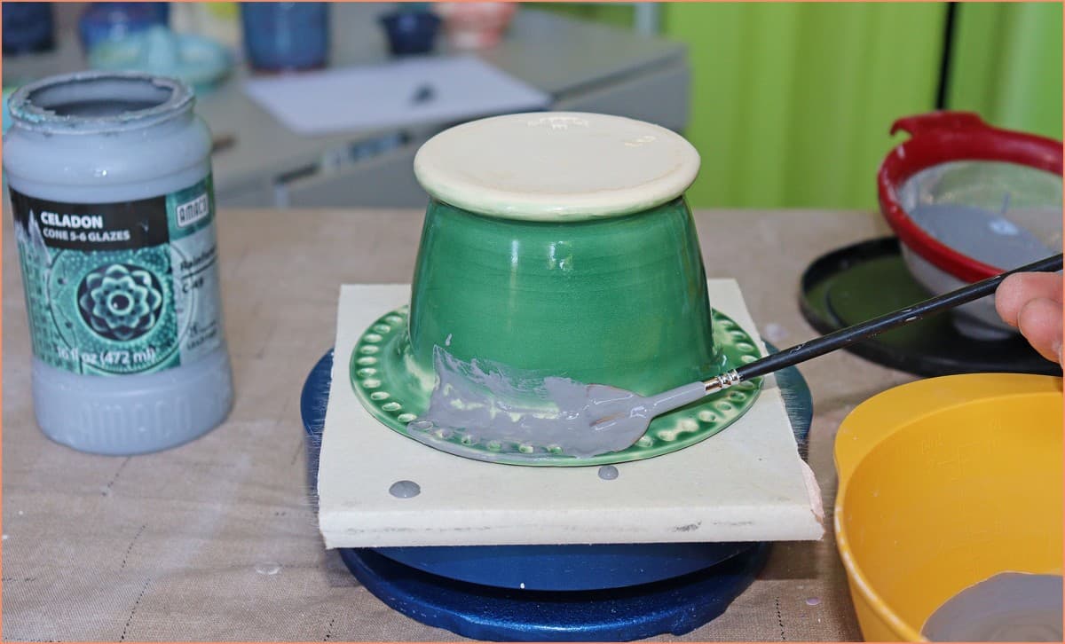 a picture of a potter reglazing the outside of an earing holder