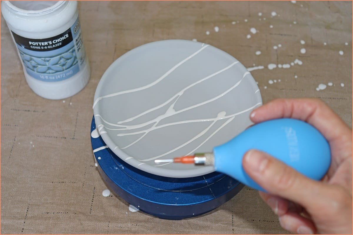 a picture of a potter trail glazing a plate