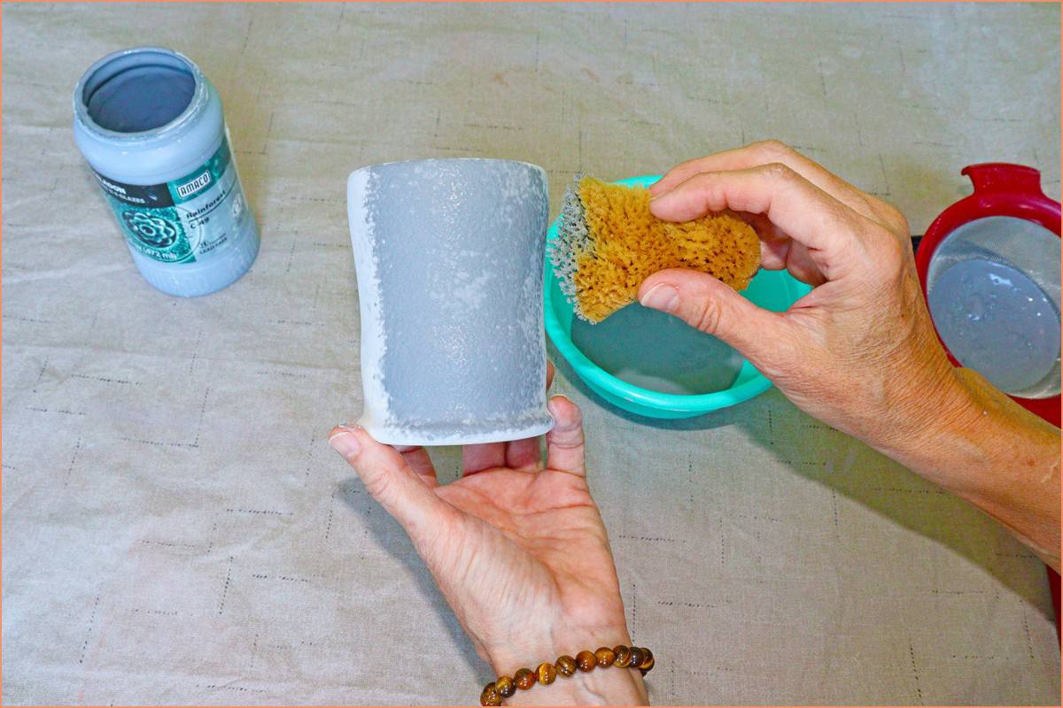 aa picture of a potter sponge glazing a mug