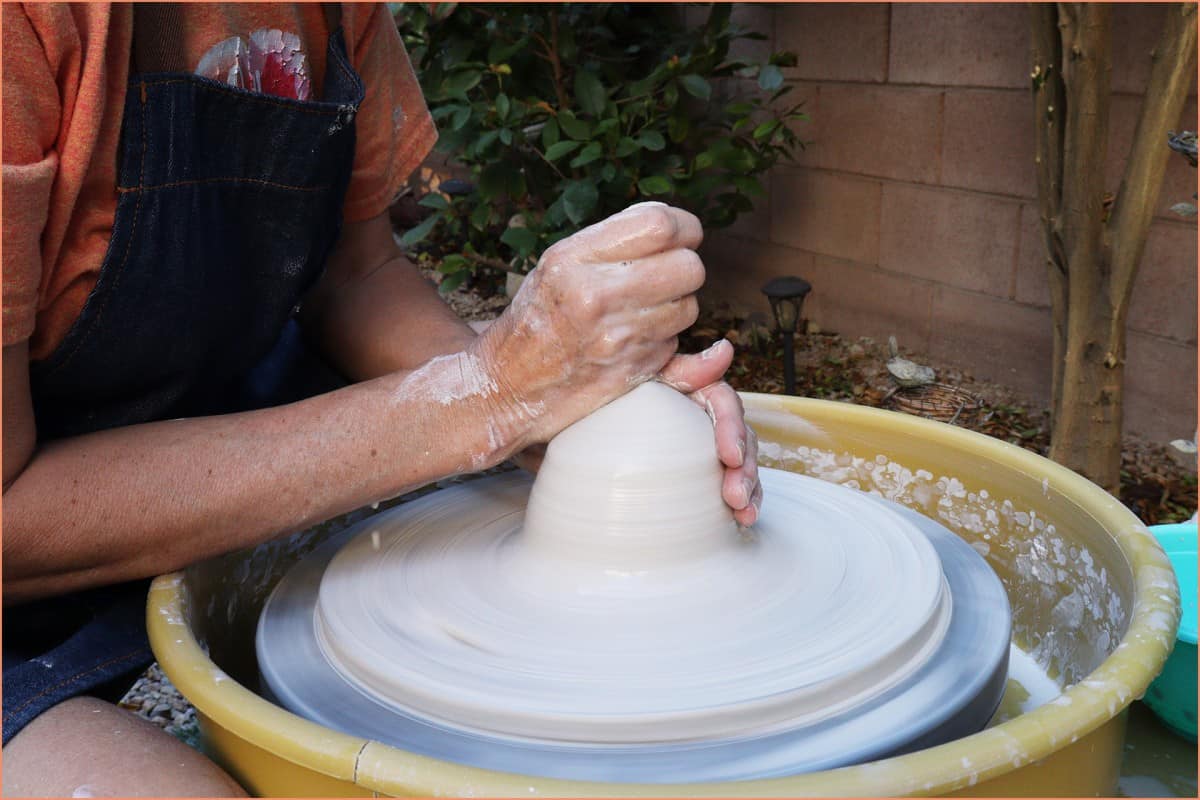 a picture of a potter centering clay