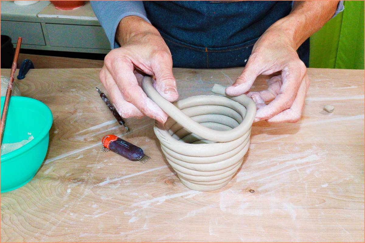 a picture of a potter making a coil pot