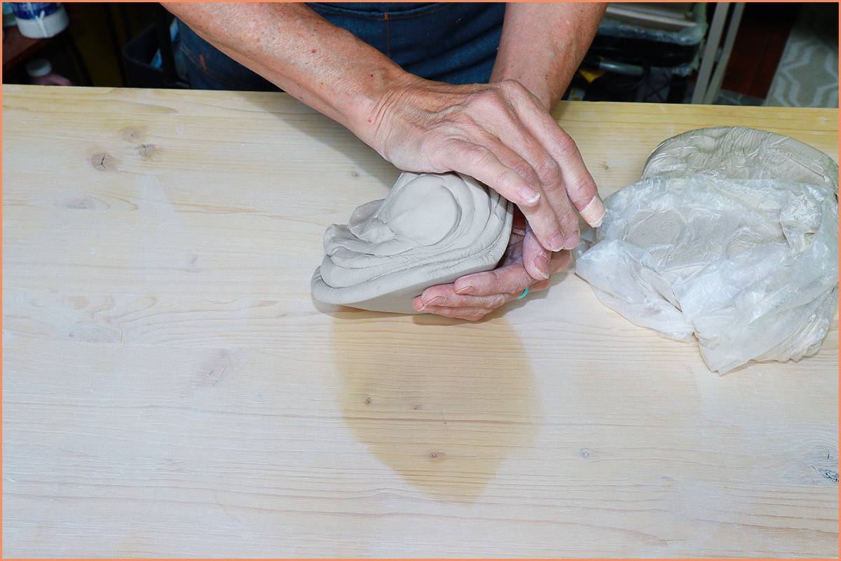 a picture of a potter wedgeing clay