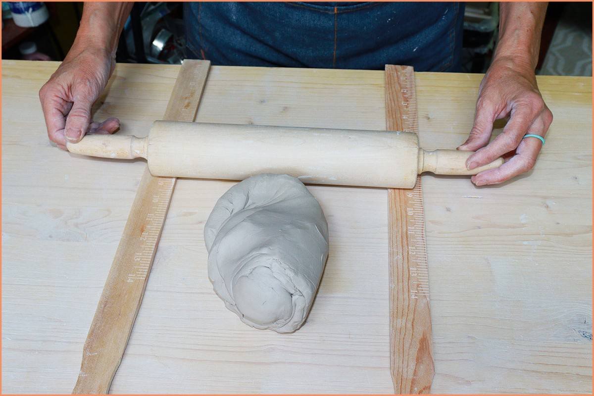 a picture of a potter placing yardsticks on wedging board