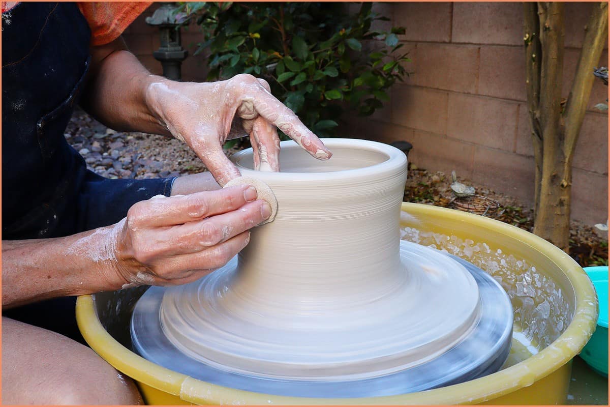 a picture of a potter Throwing a bowl outside