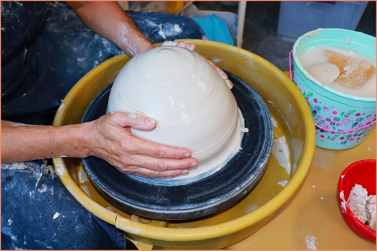 a picture of a potter centering 20 pounds of clay