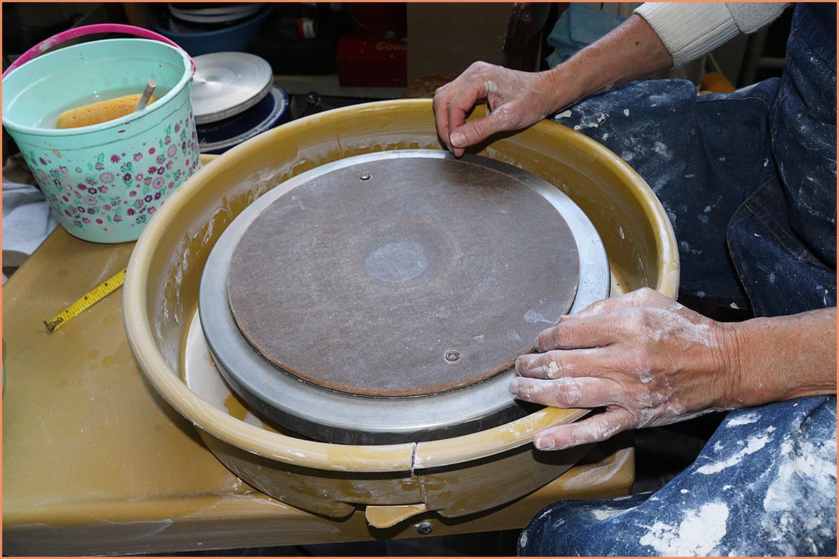 an image of a potter placing the Bat on the pottery wheel