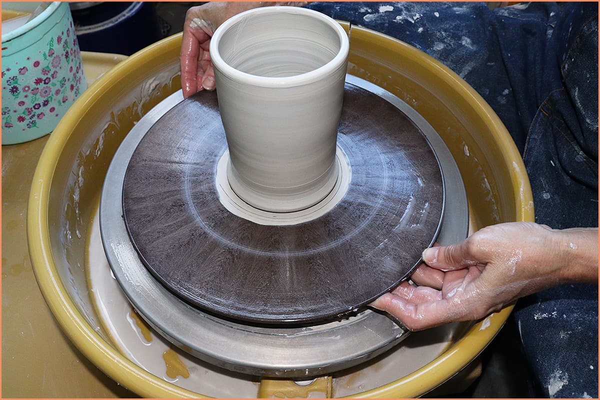 an image of a potter removing a Bat from a Pottery Wheel