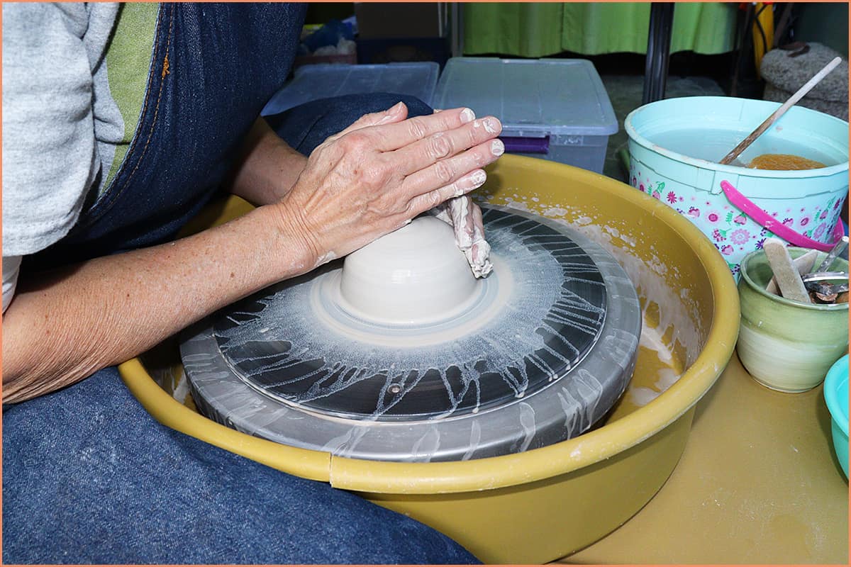 an image of a potter centering clay