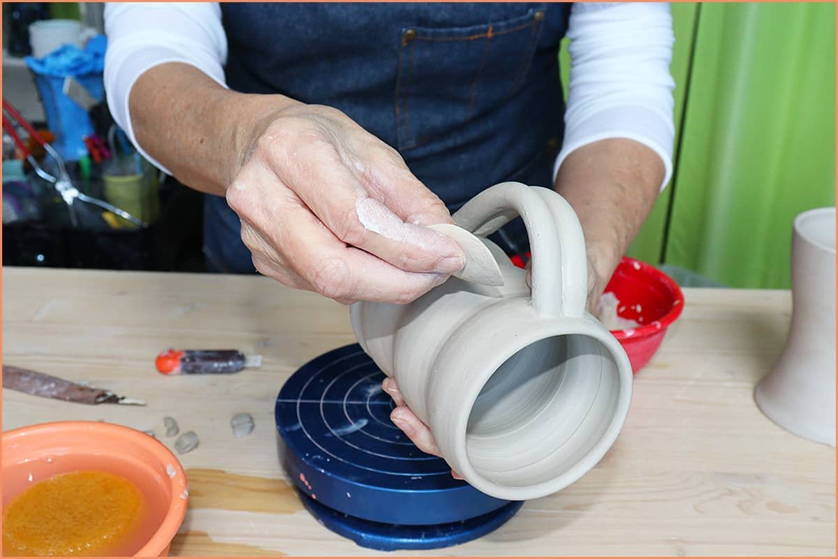 an image of a potter Smoothing out a mug