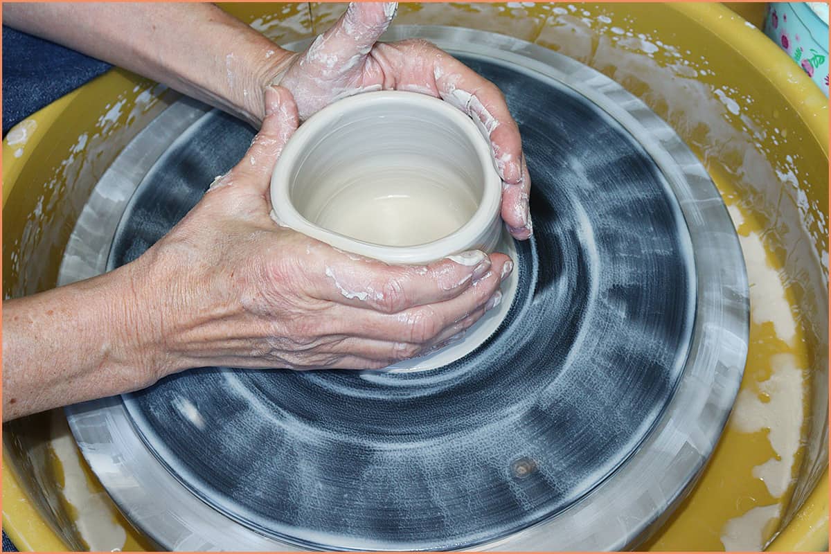 an image of a potter collaring in clay