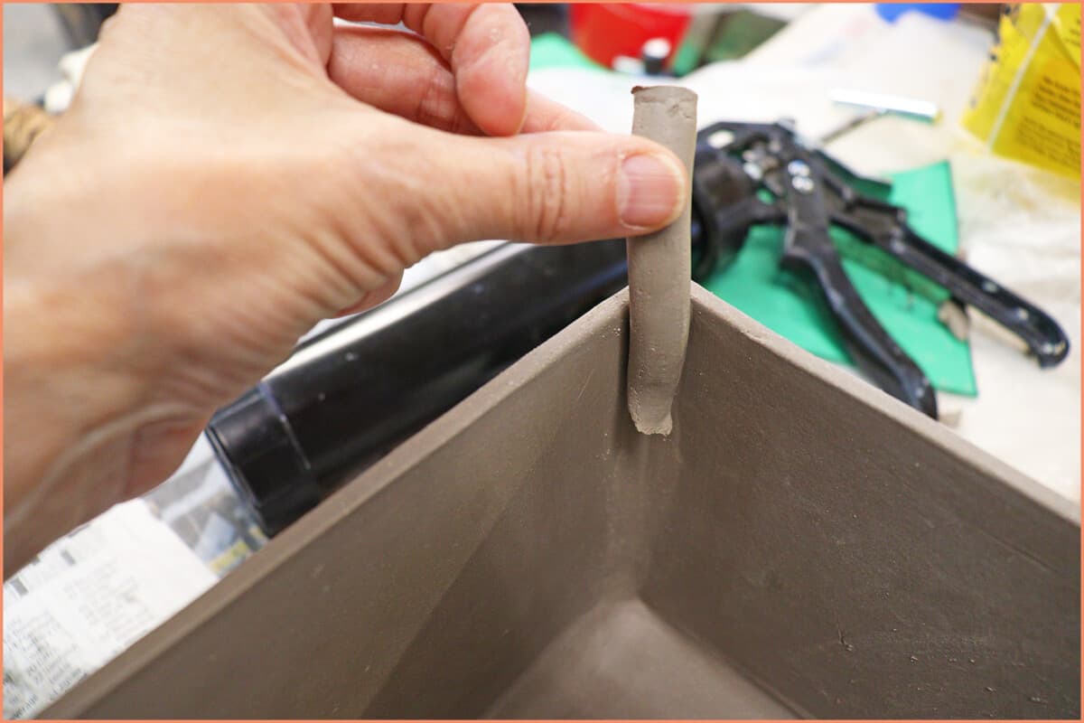 placing flat coil of clay in corner