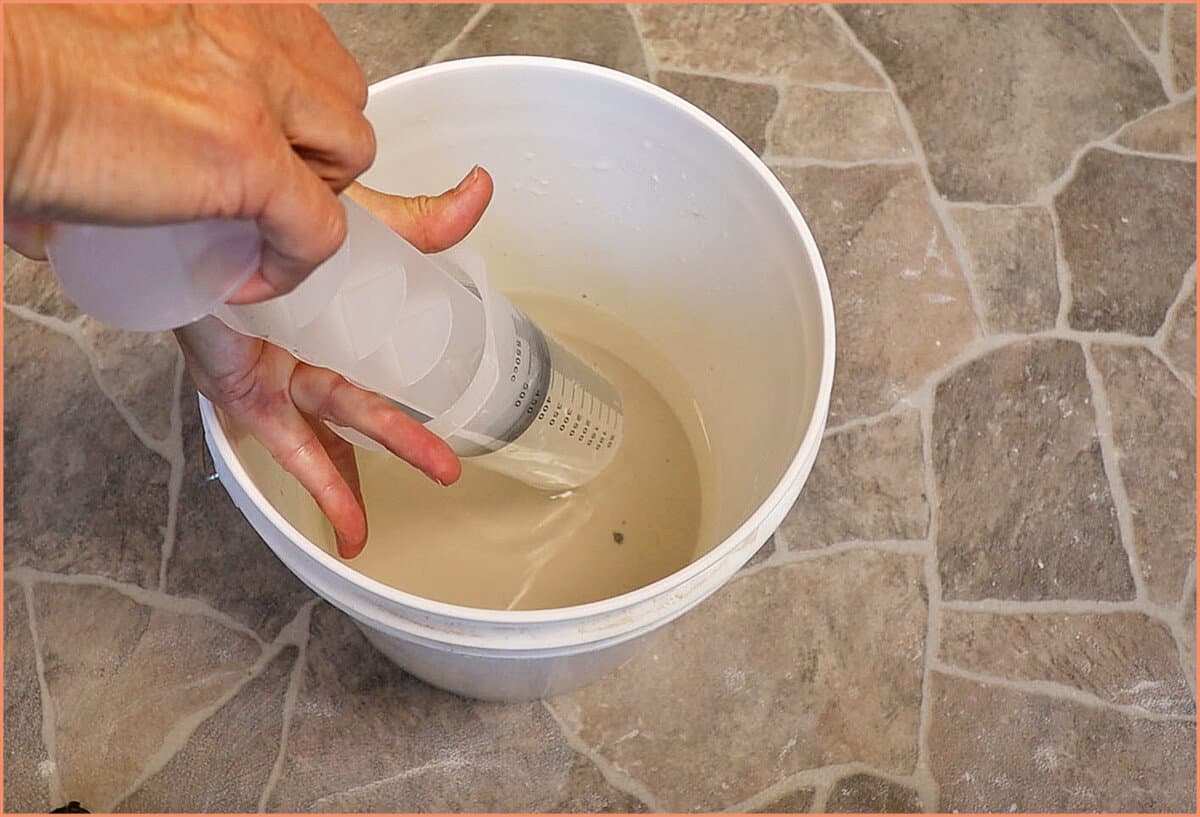 taking water out of dirty clay bucket