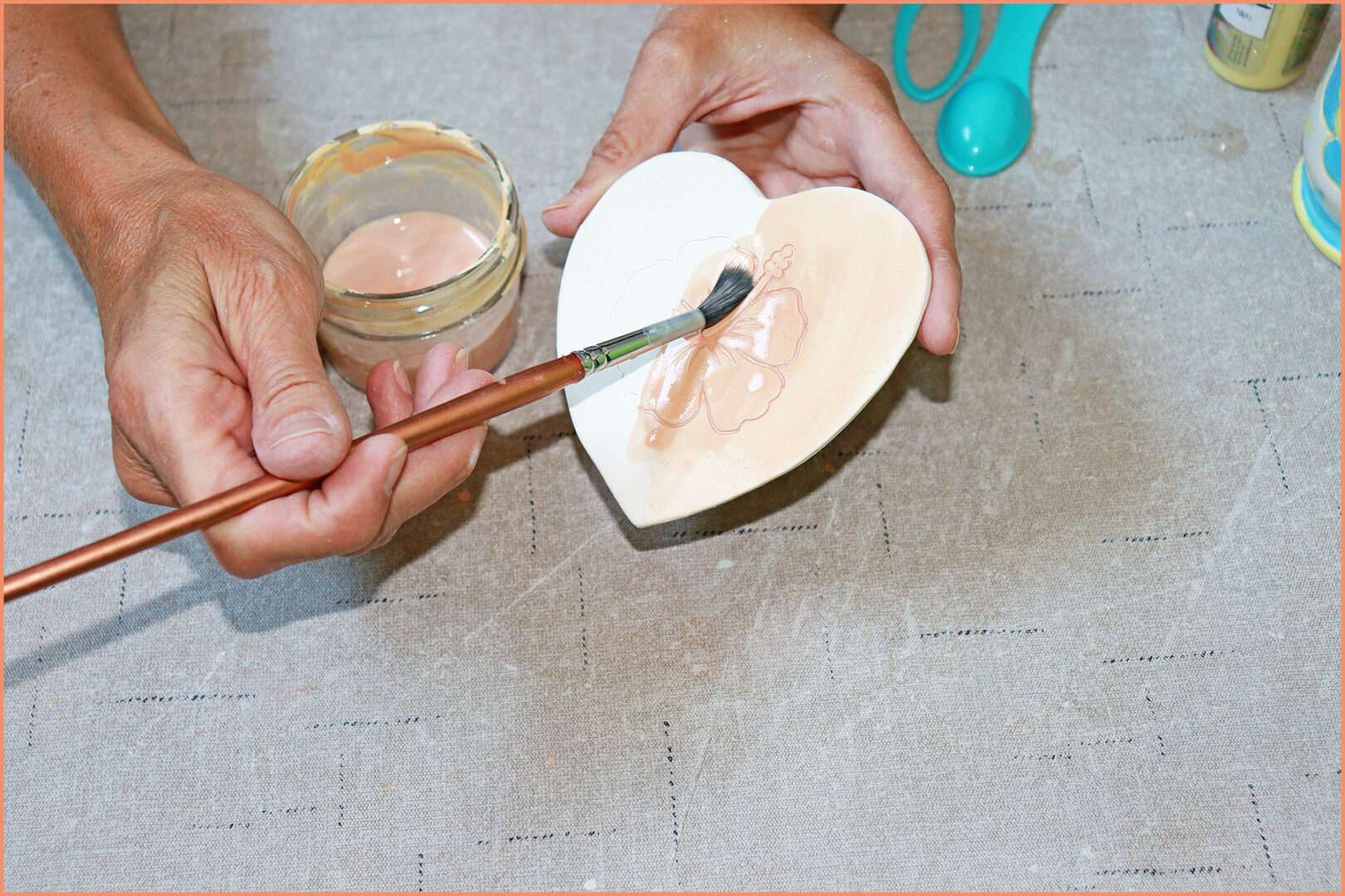 an image of a potter brushing on underglaze watercolors