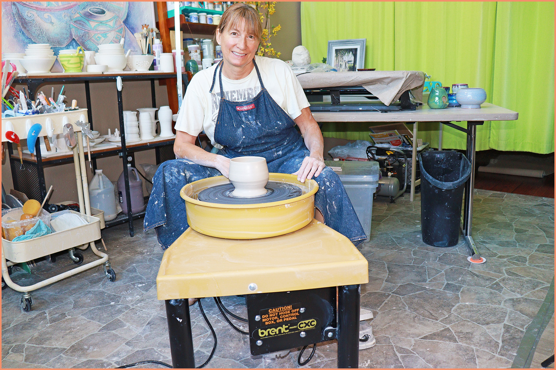 an image of a potter sitting at the pottery wheel