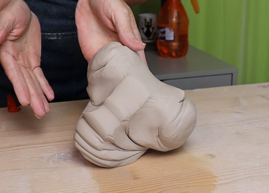 an image of a potter holding the ram's head wedge